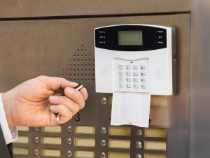 Hand mit Transponder am Eingang bei einer Einbruchmeldeanlage