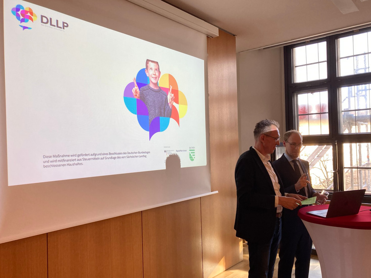 Start Projektabschlussveranstaltung DLLP mit PowerPointPräsentation im Hintergrund